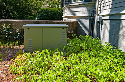 A standby generator installed outside near a house.